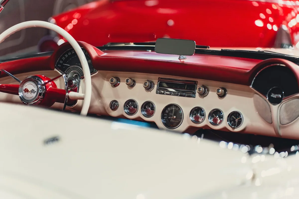 Passionné de voitures admirant un véhicule de collection lors d'un événement automobile